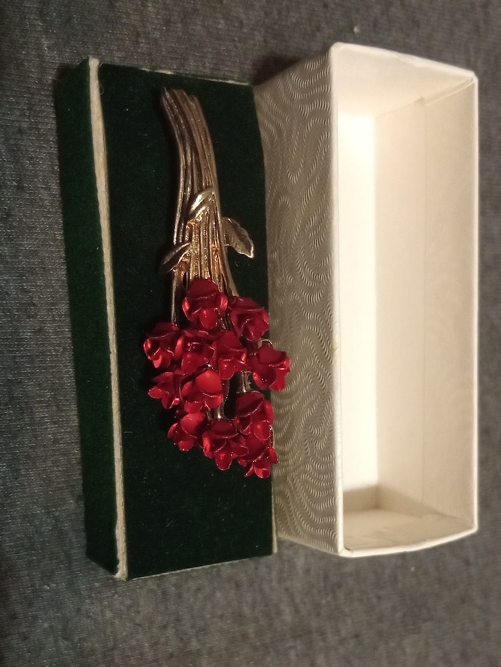 This is a vintage DM 97 brooch featuring a bouquet of red roses, typically craft